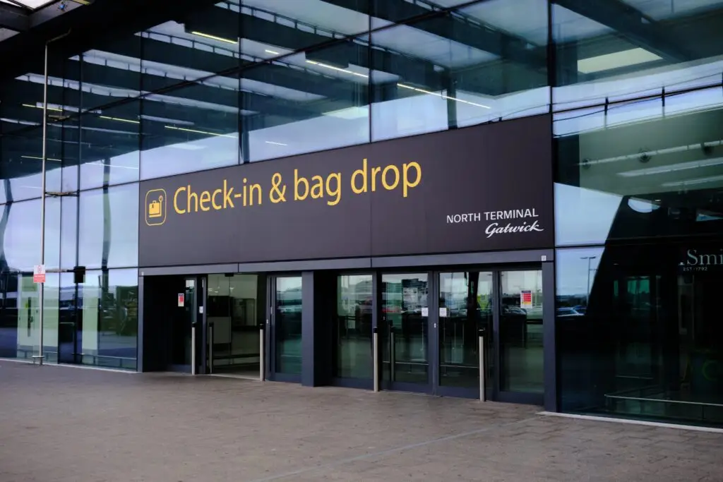 chauffeur holding name board for Windsor passenger at Gatwick arrivals